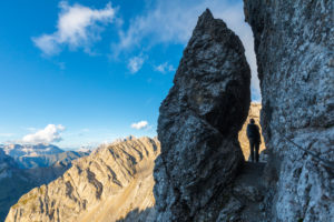 A hiker at the narrowest point of the Bepi Zac High Trail, Costabella Ridge, Marmolada group, Dolomites, Fassa Valley, Trento province, Trentino-Alto Adige, Italy A hiker at the narrowest point of the Bepi Zac High Trail, Costabella Ridge, Marmolada group, Dolomites, Fassa Valley, Trento province, Trentino-Alto Adige, Italy