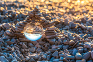 stack of pyramid-shaped pebbles with crystal ball on the beach of Mošćenička Draga at sunrise, Primorje-Gorski Kotar County, Croatia stack of pyramid-shaped pebbles with crystal ball on the beach of Mošćenička Draga at sunrise, Primorje-Gorski Kotar County, Croatia