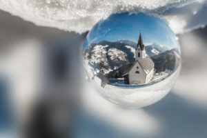 The parish churc of Rina di Marebbe - Welschellen seen through a crystal ball, municipality of Marebbe / Enneberg, Bolzano, Alto Adige, Südtirol, Italy