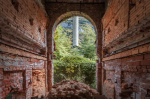 terracotta brick walls and arched window, industrial ruins, belluno, veneto, italy