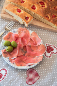 homemade Apulian focaccia served with Parma's ham and olives, typical Italian food