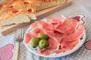 homemade Apulian focaccia served with Parma's ham and olives, typical Italian food