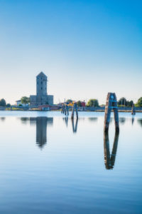 the telemetry tower Crepaldo (abandoned first world war observation tower) and the adriatic lagoon in Cavallino Treporti with the traditional poles called bricole, Venice, Veneto, Italy, Europe the telemetry tower Crepaldo (abandoned first world war observation tower) and the adriatic lagoon in Cavallino Treporti with the traditional poles called bricole, Venice, Veneto, Italy, Europe