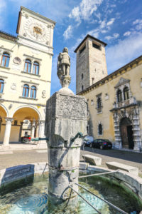 Italy, Veneto, Belluno, Dolomites, the statue of St. Gioatà on the fountain in Piazza del Duomo between the Palazzo dei Rettori with the clock tower and Palazzo dei Vescovi Italy, Veneto, Belluno, Dolomites, the statue of St. Gioatà on the fountain in Piazza del Duomo between the Palazzo dei Rettori with the clock tower and Palazzo dei Vescovi