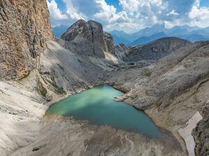 Aerial view of Lake Antermoia on a sunny summer day, nestled in the Dolomites' Catinaccio group, Val di Fassa, Trentino, Italy