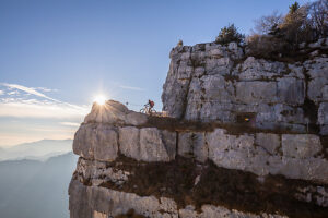Group of e-mountain bikers riding along the Granatiere Trail on Monte Cengio, Vicenza Province, Veneto, Italy