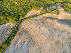 Aerial view of a cultivated field and abandoned farmhouse in the rural landscape of Cesane Park, near Urbino, Marche region, central Italy