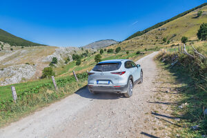 A crossover vehicle driving on a dirt road across the Bjelasnica plateau near Lukomir village, Municipality of Konjic, Herzegovina-Neretva Canton, Bosnia and Herzegovina A crossover vehicle driving on a dirt road across the Bjelasnica plateau near Lukomir village, Municipality of Konjic, Herzegovina-Neretva Canton, Bosnia and Herzegovina