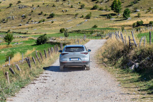 A crossover vehicle driving on a dirt road across the Bjelasnica plateau near Lukomir village, Municipality of Konjic, Herzegovina-Neretva Canton, Bosnia and Herzegovina A crossover vehicle driving on a dirt road across the Bjelasnica plateau near Lukomir village, Municipality of Konjic, Herzegovina-Neretva Canton, Bosnia and Herzegovina