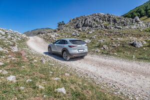 A crossover vehicle driving on a dirt road across the Bjelasnica plateau near Lukomir village, Municipality of Konjic, Herzegovina-Neretva Canton, Bosnia and Herzegovina A crossover vehicle driving on a dirt road across the Bjelasnica plateau near Lukomir village, Municipality of Konjic, Herzegovina-Neretva Canton, Bosnia and Herzegovina