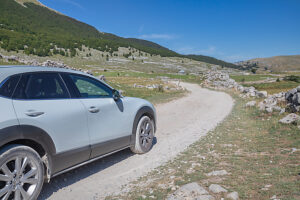 A crossover vehicle driving on a dirt road across the Bjelasnica plateau near Lukomir village, Municipality of Konjic, Herzegovina-Neretva Canton, Bosnia and Herzegovina A crossover vehicle driving on a dirt road across the Bjelasnica plateau near Lukomir village, Municipality of Konjic, Herzegovina-Neretva Canton, Bosnia and Herzegovina