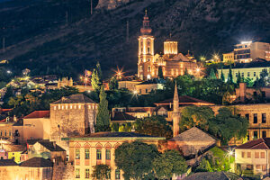 Night view of Mostar with illuminated Orthodox Cathedral, church towers, and mosque minaret, Mostar, Herzegovina-Neretva Canton, Bosnia and Herzegovina Night view of Mostar with illuminated Orthodox Cathedral, church towers, and mosque minaret, Mostar, Herzegovina-Neretva Canton, Bosnia and Herzegovina