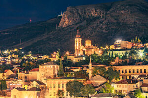 Night view of Mostar with illuminated Orthodox Cathedral, church towers, and mosque minaret, Mostar, Herzegovina-Neretva Canton, Bosnia and Herzegovina Night view of Mostar with illuminated Orthodox Cathedral, church towers, and mosque minaret, Mostar, Herzegovina-Neretva Canton, Bosnia and Herzegovina