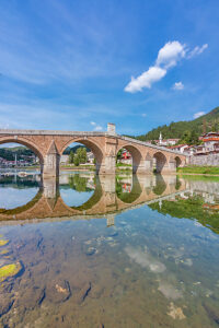 Historic Ottoman stone bridge Stara Cuprija (Old Bridge) reflected in the clear waters of the Neretva River, Konjic, Herzegovina-Neretva Canton, Bosnia and Herzegovina Historic Ottoman stone bridge Stara Cuprija (Old Bridge) reflected in the clear waters of the Neretva River, Konjic, Herzegovina-Neretva Canton, Bosnia and Herzegovina