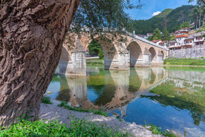 Historic Ottoman stone bridge Stara Cuprija (Old Bridge) reflected in the clear waters of the Neretva River, Konjic, Herzegovina-Neretva Canton, Bosnia and Herzegovina Historic Ottoman stone bridge Stara Cuprija (Old Bridge) reflected in the clear waters of the Neretva River, Konjic, Herzegovina-Neretva Canton, Bosnia and Herzegovina