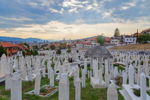 Kovaci Cemetery with white tombstones in the foreground and panoramic view of Sarajevo under dramatic cloudy sky, Bosnia and Herzegovina Kovaci Cemetery with white tombstones in the foreground and panoramic view of Sarajevo under dramatic cloudy sky, Bosnia and Herzegovina