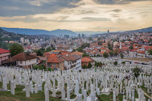 Kovaci Cemetery with white tombstones in the foreground and panoramic view of Sarajevo under dramatic cloudy sky, Bosnia and Herzegovina Kovaci Cemetery with white tombstones in the foreground and panoramic view of Sarajevo under dramatic cloudy sky, Bosnia and Herzegovina
