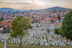 Kovaci Cemetery with white tombstones in the foreground and panoramic view of Sarajevo under dramatic cloudy sky, Bosnia and Herzegovina Kovaci Cemetery with white tombstones in the foreground and panoramic view of Sarajevo under dramatic cloudy sky, Bosnia and Herzegovina