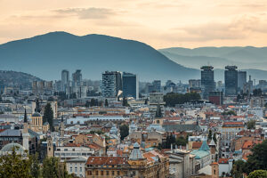 Panoramic view of Sarajevo with mix of historic rooftops, churches, mosques and modern skyscrapers, surrounded by mountains, Bosnia and Herzegovina Panoramic view of Sarajevo with mix of historic rooftops, churches, mosques and modern skyscrapers, surrounded by mountains, Bosnia and Herzegovina