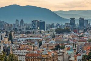 Panoramic view of Sarajevo with mix of historic rooftops, churches, mosques and modern skyscrapers, surrounded by mountains, Bosnia and Herzegovina Panoramic view of Sarajevo with mix of historic rooftops, churches, mosques and modern skyscrapers, surrounded by mountains, Bosnia and Herzegovina