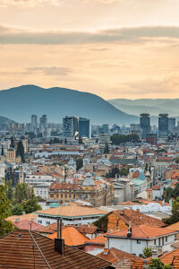 Panoramic view of Sarajevo with mix of historic rooftops, churches, mosques and modern skyscrapers, surrounded by mountains, Bosnia and Herzegovina Panoramic view of Sarajevo with mix of historic rooftops, churches, mosques and modern skyscrapers, surrounded by mountains, Bosnia and Herzegovina