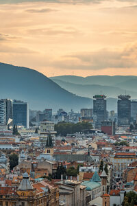 Panoramic view of Sarajevo with mix of historic rooftops, churches, mosques and modern skyscrapers, surrounded by mountains, Bosnia and Herzegovina Panoramic view of Sarajevo with mix of historic rooftops, churches, mosques and modern skyscrapers, surrounded by mountains, Bosnia and Herzegovina