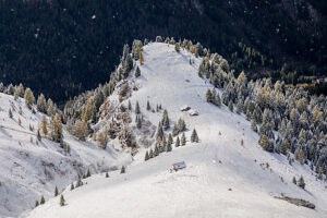 Light and shadow play over the snowy slopes above Penia, a hamlet of Canazei in Val di Fassa, early autumn snow dusts the larch trees and alpine huts, autonomous Province of Trento, Trentino-Alto Adige, Italy Light and shadow play over the snowy slopes above Penia, a hamlet of Canazei in Val di Fassa, early autumn snow dusts the larch trees and alpine huts, autonomous Province of Trento, Trentino-Alto Adige, Italy