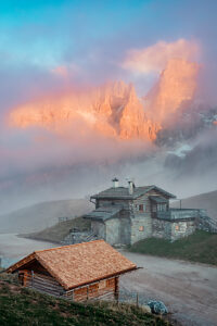 Sunset light and mist envelop the Baita Segantini and the Pale di San Martino peaks in a magical alpine atmosphere. Primiero San Martino di Castrozza, Trento province, Trentino, Italy Sunset light and mist envelop the Baita Segantini and the Pale di San Martino peaks in a magical alpine atmosphere. Primiero San Martino di Castrozza, Trento province, Trentino, Italy
