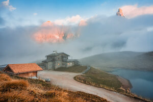 Baita Segantini surrounded by evening mist as the last light of sunset colors the Pale di San Martino peaks. Primiero San Martino di Castrozza, Trento province, Trentino, Italy Baita Segantini surrounded by evening mist as the last light of sunset colors the Pale di San Martino peaks. Primiero San Martino di Castrozza, Trento province, Trentino, Italy
