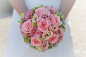 Bride holds pink bridal bouquet in hands, close up Bride holds pink bridal bouquet in hands, close up