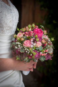 Bride holds pink bridal bouquet in hands