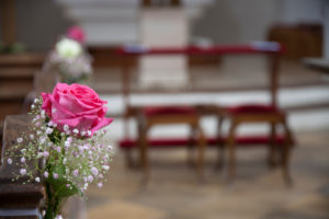 pink rose on pew, flower arrangements for wedding