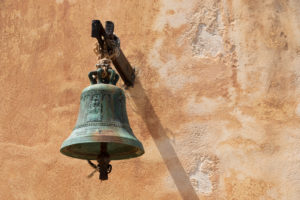 Bell in front of a ocherous house wall, Greece, Crete, Spinalonga Island, Kalydon Bell in front of a ocherous house wall, Greece, Crete, Spinalonga Island, Kalydon