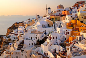 Village view on the slope of the cliff coast with windmills, Ia, (Oia), Santorin, (Thira), Cyclades, Aegean Islands, Aegean Sea, Greece, evening sun Village view on the slope of the cliff coast with windmills, Ia, (Oia), Santorin, (Thira), Cyclades, Aegean Islands, Aegean Sea, Greece, evening sun