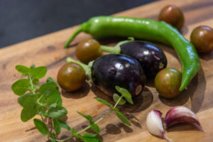 Harvesting aubergines and cooking them vegetarian: healthy and sustainable nutrition from your own garden. Freshly harvested vegetables on a wooden board. Harvesting aubergines and cooking them vegetarian: healthy and sustainable nutrition from your own garden. Freshly harvested vegetables on a wooden board.