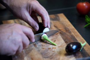 Harvesting aubergines and cooking them vegetarian: healthy and sustainable nutrition from your own garden. Cut eggplant with a santoku knife. Harvesting aubergines and cooking them vegetarian: healthy and sustainable nutrition from your own garden. Cut eggplant with a santoku knife.