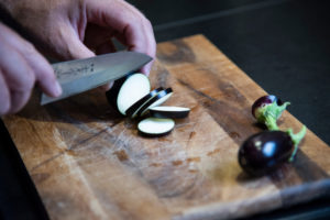 Harvesting aubergines and cooking them vegetarian: healthy and sustainable nutrition from your own garden. Cut eggplant with a santoku knife. Harvesting aubergines and cooking them vegetarian: healthy and sustainable nutrition from your own garden. Cut eggplant with a santoku knife.