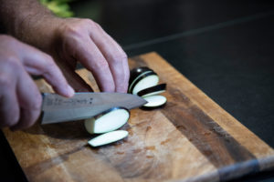 Harvesting aubergines and cooking them vegetarian: healthy and sustainable nutrition from your own garden. Cut eggplant with a santoku knife. Harvesting aubergines and cooking them vegetarian: healthy and sustainable nutrition from your own garden. Cut eggplant with a santoku knife.