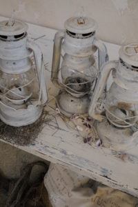 old white lanterns on shabby chic shelf with net and mussels old white lanterns on shabby chic shelf with net and mussels