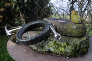 Hunting horn on moss-covered stone beside stone bird bath Hunting horn on moss-covered stone beside stone bird bath