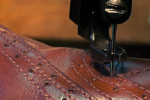 Sewing machine needle, leather shoe, production, seam, close-up Sewing machine needle, leather shoe, production, seam, close-up