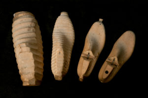 Handmade wooden models in shoemaker's workshop, work piece from rough to fine on black ground Handmade wooden models in shoemaker's workshop, work piece from rough to fine on black ground