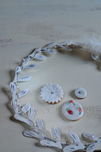 Cookies with white fondant coating surrounded by white metal wreath Cookies with white fondant coating surrounded by white metal wreath