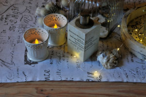 Christmas table decoration in white with artificial candles and fairy lights Christmas table decoration in white with artificial candles and fairy lights