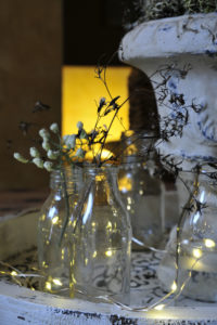 Christmas table decoration, bottles with filigree branches and fairy lights Christmas table decoration, bottles with filigree branches and fairy lights