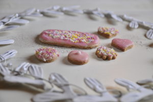 Cookies with pink fondant coating and colorful caster sugar with white metal wreath Cookies with pink fondant coating and colorful caster sugar with white metal wreath