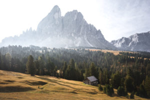 The summit chain of the Peitlerkofel in autumn and sunrise in front of an alpine meadow, forest and hut in the Dolomites, South Tyrol, Italy The summit chain of the Peitlerkofel in autumn and sunrise in front of an alpine meadow, forest and hut in the Dolomites, South Tyrol, Italy
