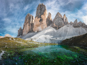 The summit of the Drei Zinnen in front of a turquoise mountain lake and a dramatic sky in the Dolomites, South Tyrol, Italy The summit of the Drei Zinnen in front of a turquoise mountain lake and a dramatic sky in the Dolomites, South Tyrol, Italy