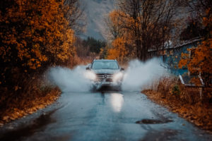 An off-road vehicle drives through a puddle on the island of Senja in Norway in autumn An off-road vehicle drives through a puddle on the island of Senja in Norway in autumn