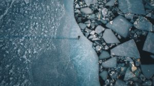 A lonely person on a lip in the Baltic Sea on the coast of Turku, Finland. The ice floes are created by the passage of ferries and ships A lonely person on a lip in the Baltic Sea on the coast of Turku, Finland. The ice floes are created by the passage of ferries and ships